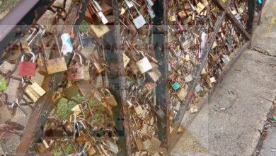 الشباب والفتيات فى سن المراهقة يكتبون أسماءهم وعبارات الحب على الاقفال